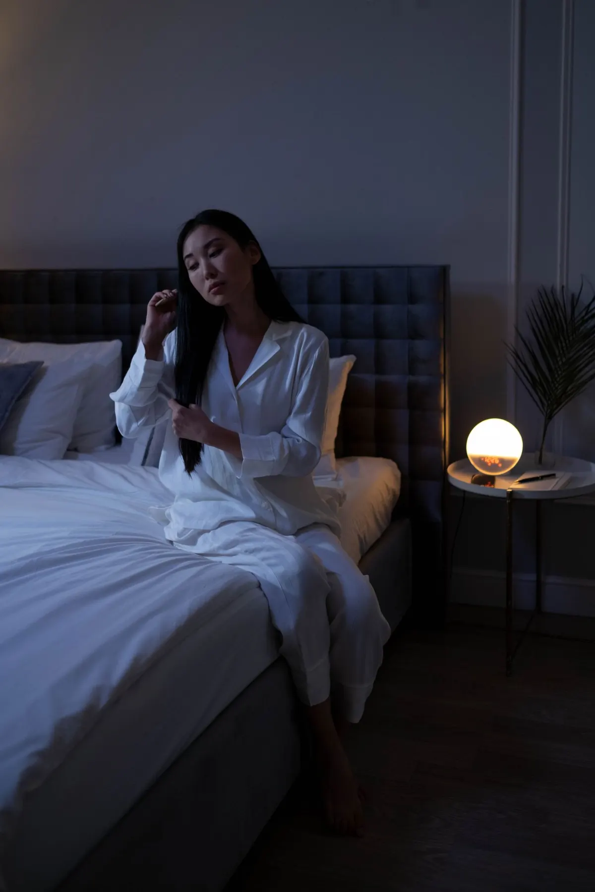 身着舒适家居服的女性在卧室温馨休憩，展现早秋居家松弛感